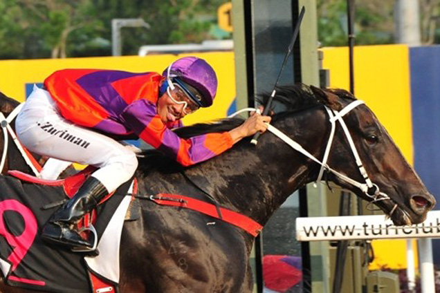 Zuriman Zulkifli poses for the camera by cheekily sticking his tongue out as he drives Cheetah On Fire across the line.