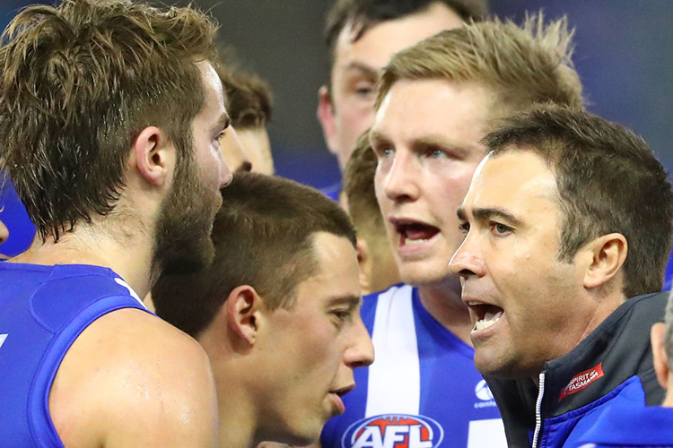 BRAD SCOTT coach of the Kangaroos speaks to his team during a quarter time break with Jack Ziebell of the Kangaroos during an AFL match between the North Melbourne Kangaroos and the Fremantle Dockers at Etihad Stadium in Melbourne, Australia.