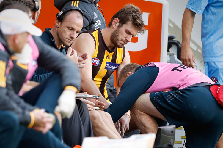 GRANT BIRCHALL of the Hawks has his knee strapped after coming off injured for the day during the 2017 AFL match between the Melbourne Demons and the Hawthorn Hawks at the MCG in Melbourne, Australia.