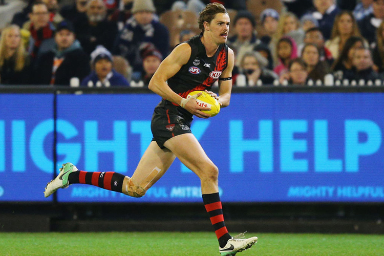 JOE DANIHER of the Bombers runs with the ball during the AFL match between the Essendon Bombers and the Geelong Cats at MCG in Melbourne, Australia.