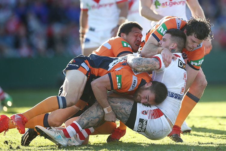 JOSH DUGAN of the Dragons is tackled during the NRL match between the St George Illawarra Dragons and the Newcastle Knights at UOW Jubilee Oval in Sydney, Australia.
