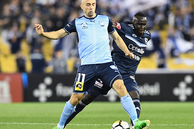 THOMAS DENG of the Victory and ADRIAN MIERZEJEWSKI of Sydney FC compete for the ball during the A-League match between the Melbourne Victory and Sydney FC at Etihad Stadium in Melbourne, Australia.