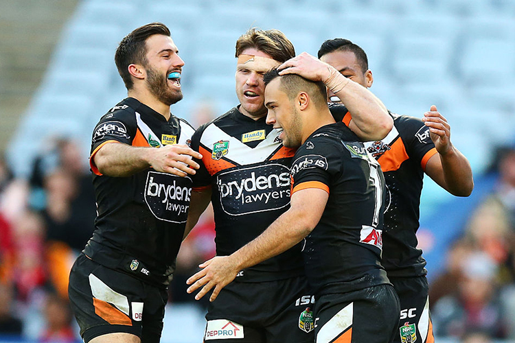 Tigers players celebrate a try by LUKE BROOKS during the NRL match between the St George Illawarra Dragons and the Wests Tigers at ANZ Stadium in Sydney, Australia.