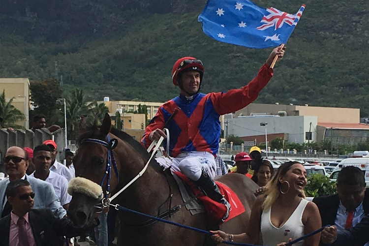 Dwayne Dunn waves the Australian flag as he is led back in by Horse Guards' connections.
