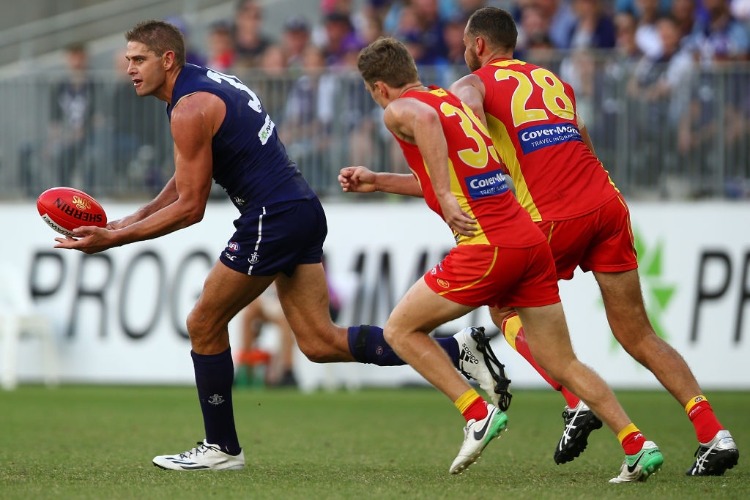 AARON SANDILANDS of the Dockers handballs during the AFL match between the Gold Coast Suns and the Fremantle Dockers at Optus Stadium in Perth, Australia.
