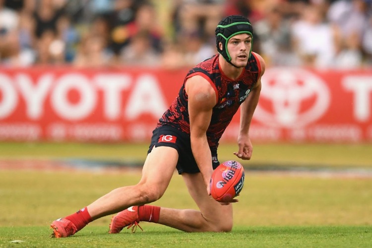 ANGUS BRAYSHAW of the Demons handballs during the AFL match between the Melbourne Demons and the Adelaide Crows at Traeger Park in Alice Springs, Australia.