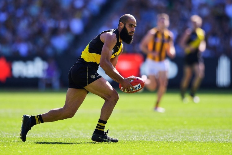 BACHAR HOULI of the Tigers runs the ball during the AFL match between the Richmond Tigers and the Hawthorn Hawks at MCG in Melbourne, Australia.