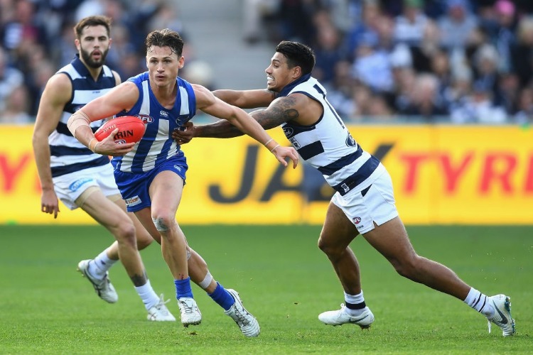 BEN JACOBS of the Kangaroos is tackled by TIM KELLY of the Cats during the AFL match between the Geelong Cats and the North Melbourne Kangaroos at GMHBA Stadium in Geelong, Australia.