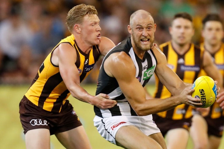 BEN REID of the Magpies is tackled by JAMES SICILY of the Hawks during the AFL match between the Hawthorn Hawks and the Collingwood Magpies at the MCG in Melbourne, Australia.