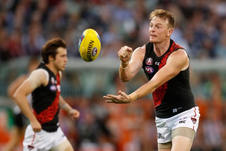 BRENDON GODDARD of the Bombers handpasses the ball during the 2018 AFL ANZAC Day match between the Collingwood Magpies and the Essendon Bombers at the MCG in Melbourne, Australia.