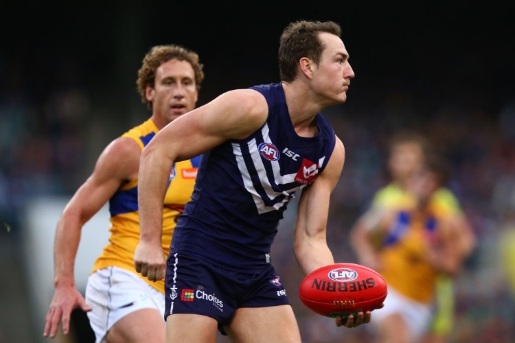 BRENNAN COX of the Dockers looks to handball during the AFL match between the Fremantle Dockers and the West Coast Eagles at Domain Stadium in Perth, Australia.