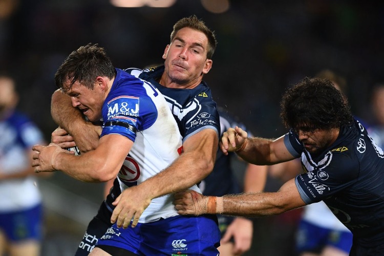 BRETT MORRIS of the Bulldogs is tackled by Scott Bolton and Jake Granville of the Cowboys during the NRL match between the North Queensland Cowboys and the Canterbury Bulldogs at 1300SMILES Stadium in Townsville, Australia.