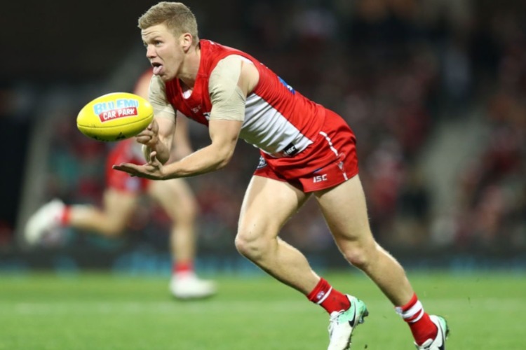 DAN HANNEBERY of the Swans handballs during the AFL match between the Sydney Swans and the Essendon Bombers at SCG in Sydney, Australia.