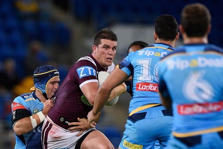DARCY LUSSICK of the Sea Eagles is tackled during the NRL match between the Gold Coast Titans and the Manly Sea Eagles at Cbus Super Stadium in Gold Coast, Australia.