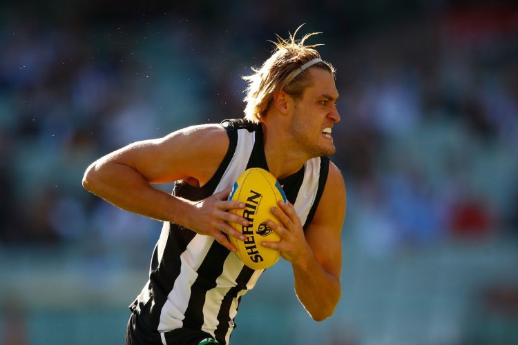 DARCY MOORE of the Magpies runs with the ball during the AFL match between the Collingwood Magpies and the Greater Western Sydney Giants at MCG in Melbourne, Australia.