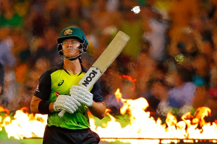 D'ARCY SHORT of Australia walks onto the field to bat through flames during the International Twenty20 series between Australia and England at MCG in Melbourne, Australia.