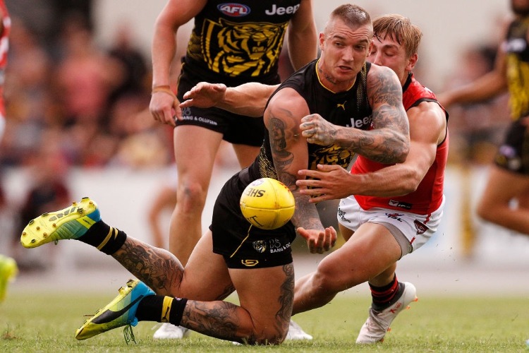 DUSTIN MARTIN of the Tigers handpasses the ball under pressure during the JLT Community Series AFL match between the Essendon Bombers a