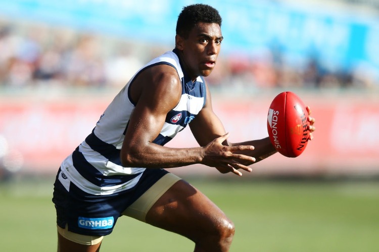 ESAVA RATUGOLEA of the Cats runs with the ball during AFL match between the Geelong Cats and Sydney Swans at GMHBA Stadium in Geelong, Australia.