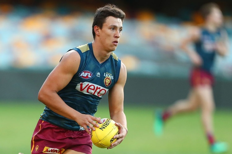 HUGH MCCLUGGAGE runs the ball during the Brisbane Lions AFL training session at The Gabba in Brisbane, Australia.