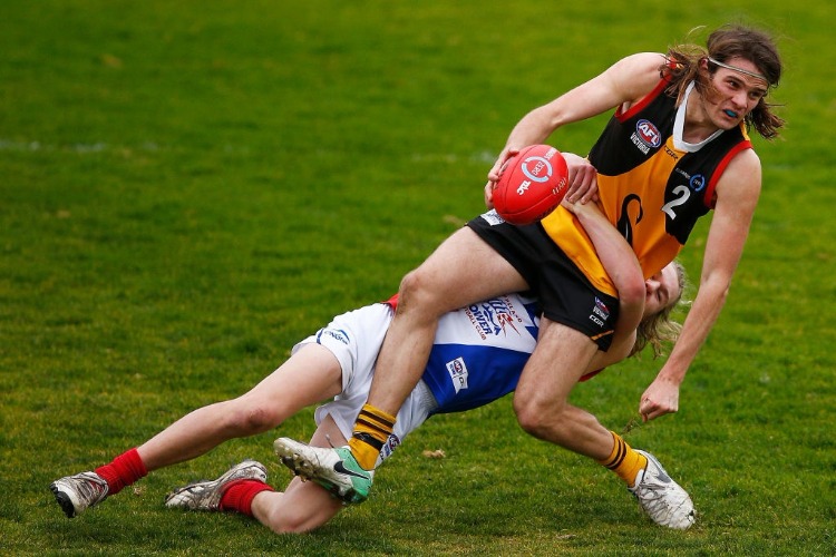 HUNTER CLARK of the Stingrays is tackled by Bailey Beck of the Power during the round 14 TAC Cup match between Dandenong and Gippsland