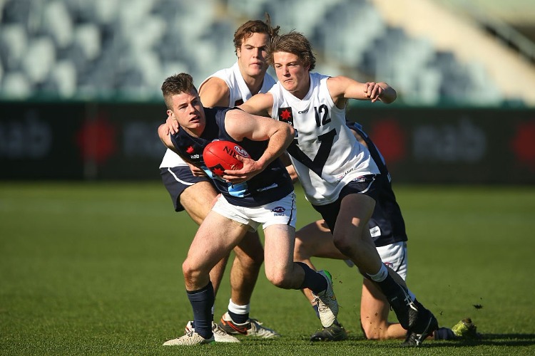 JACK HIGGINS of Vic Metro (L) is tackled during the Under 18's AFL match between Vic Country and Vic Metro at Simonds Stadium in Geelong, Australia.