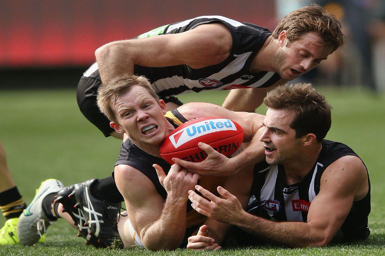 STEELE SIDEBOTTOM of the Magpies competes for the ball against JACK RIEWOLDT of the Tigers (L) during the AFL match between the Collingwood Magpies and the Richmond Tigers at MCG in Melbourne, Australia.