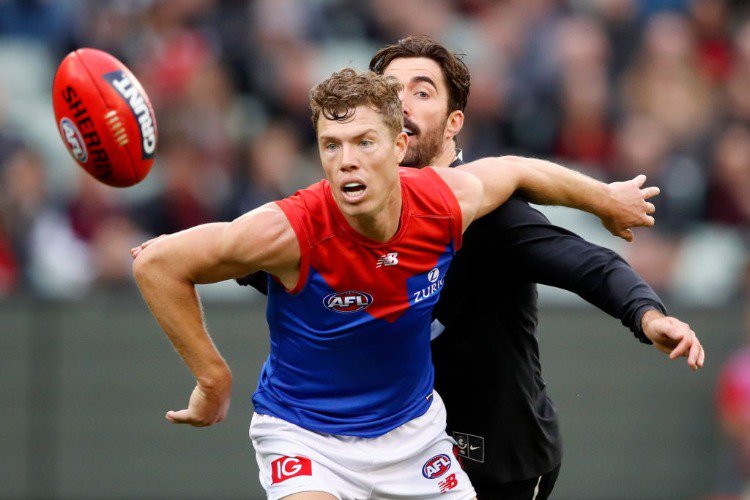 JAKE MELKSHAM of the Demons and Kade Simpson of the Blues compete for the ball during the 2018 AFL match between the Carlton Blues and the Melbourne Demons at the MCG in Melbourne, Australia.