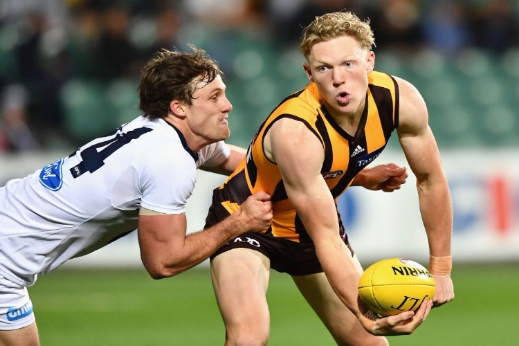 JAMES SICILY of the Hawks handballs whilst being tackled by Jed Bews of the Cats during the 2017 JLT Community Series match between the Hawthorn Hawks and the Geelong Cats at University of Tasmania Stadium in Launceston, Australia.