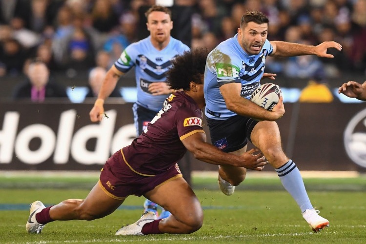 JAMES TEDESCO of the Blues is tackled by Felipe Kaufusi of the Maroons during the State Of Origin series between the Queensland Maroons and the New South Wales Blues at the MCG in Melbourne, Australia.