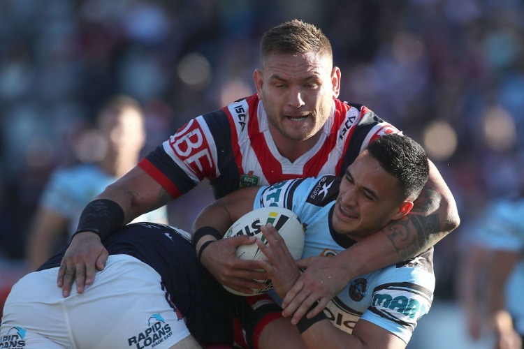 VALENTINE HOLMES of the Sharks is tackled by JARED WAEREA-HARGREAVES of the Roosters during the NRL match between the Sydney Roosters and the Cronulla Sharks at Central Coast Stadium in Gosford, Australia.