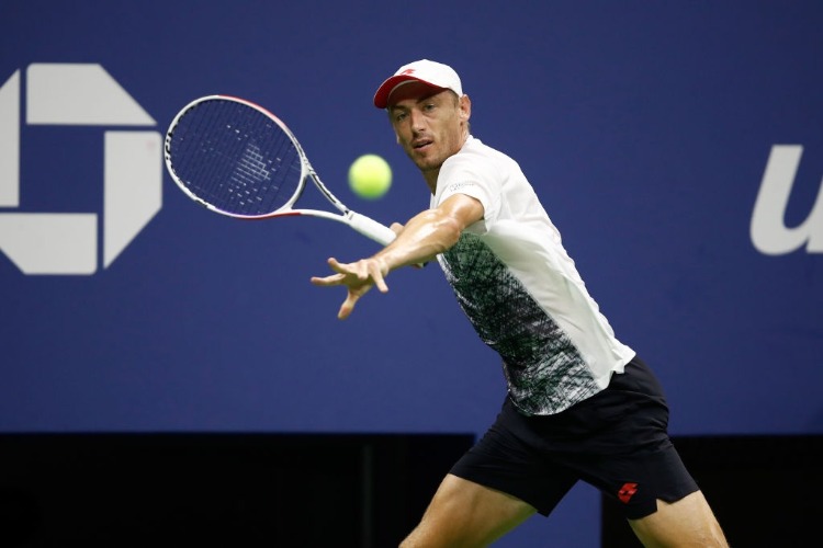 JOHN MILLMAN of Australia returns the ball during his men's singles quarter-final match against Novak Djokovic of Serbia of the US Open at the USTA Billie Jean King National Tennis Center in New York City.