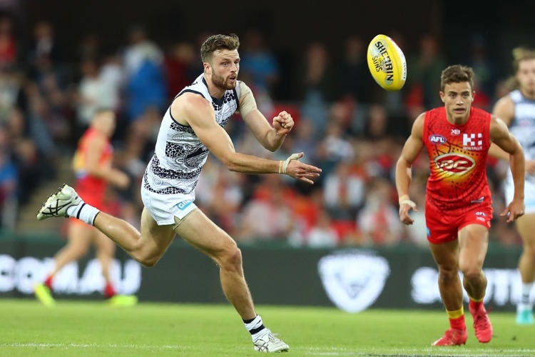 JORDAN MURDOCH of the Cats handballs during the AFL match between the Gold Coast Suns and the Geelong Cats at Metricon Stadium in Gold Coast, Australia.
