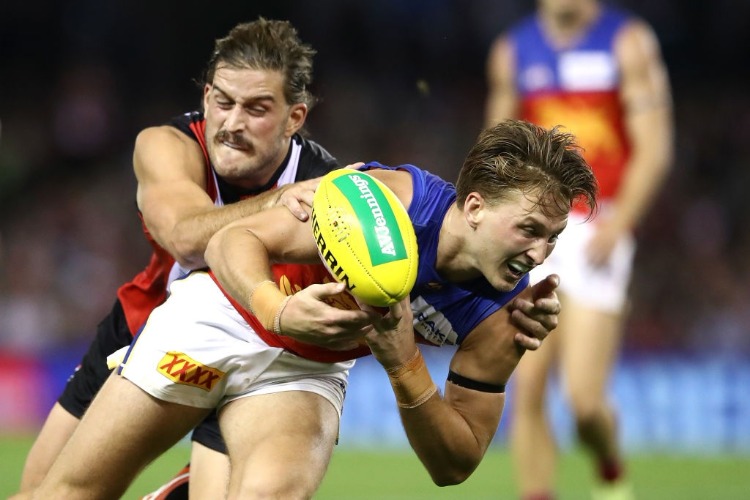 ALEX WITHERDEN of the Lions is tackled by JOSH BRUCE of the Saints during the AFL match between the St Kilda Saints and the Brisbane Lions at Etihad Stadium in Melbourne, Australia.