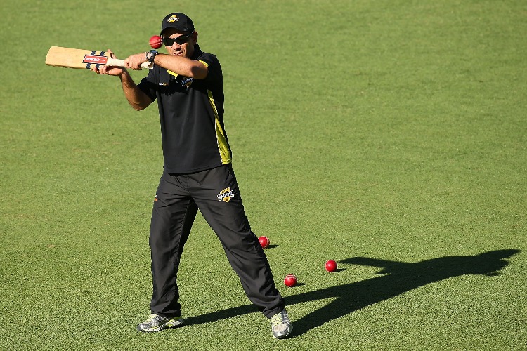 Warriors coach JUSTIN LANGER hits balls for catching practice at the change of innings during the Sheffield Shield match between the Western Australia Warriors and the South Australia Redbacks at WACA Perth, Australia.