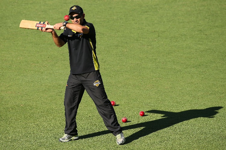 JUSTIN LANGER hits balls for catching practice.