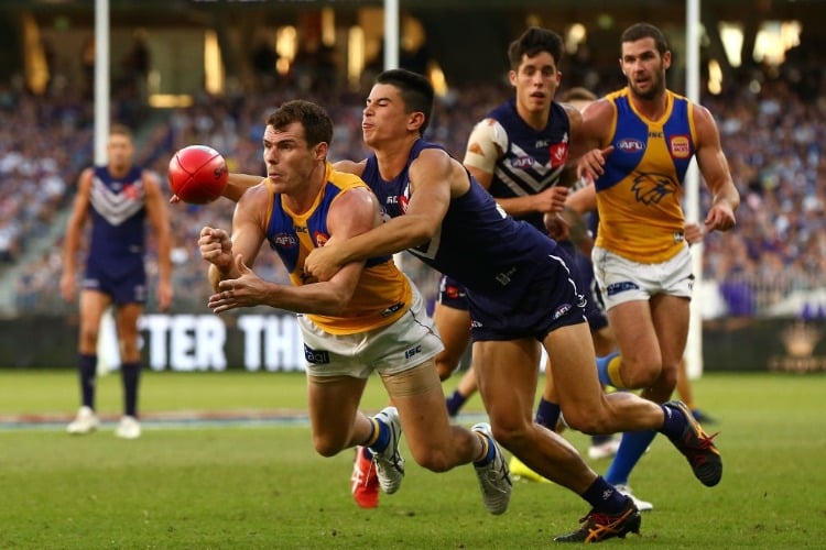LUKE SHUEY of the Eagles gets his handball away against Bailey Banfield of the Dockers during the AFL match between the Fremantle Dockers and West Coast Eagles at Optus Stadium in Perth, Australia.