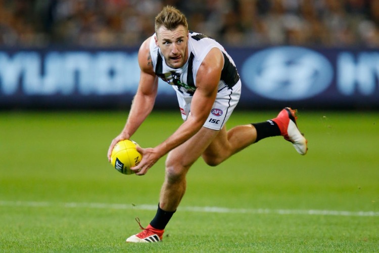 LYNDEN DUNN of the Magpies gathers the ball during the AFL match between the Carlton Blues and the Collingwood Magpies at MCG in Melbourne, Australia.
