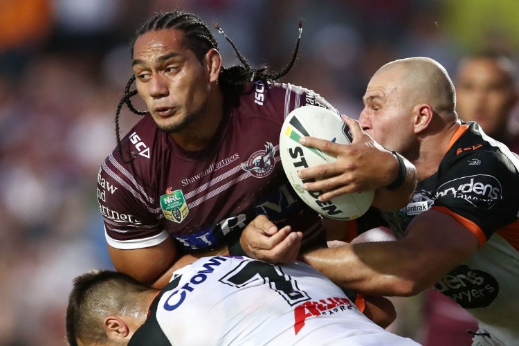 MARTIN TAUPAU of the Sea Eagles is tackled by the Tigers defence during the NRL match between the Manly Sea Eagles and the Wests Tigers at Lottoland in Sydney, Australia.
