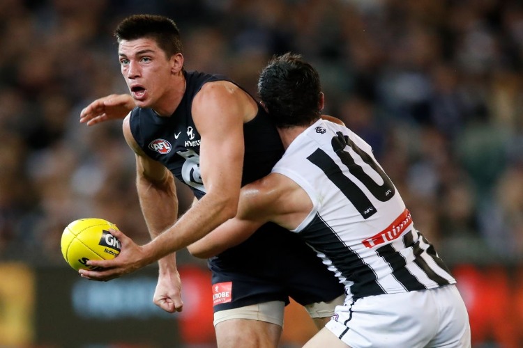MATTHEW KREUZER of the Blues is tackled by Scott Pendlebury of the Magpies during the 2018 AFL match between the Carlton Blues and the Collingwood Magpies at the MCG in Melbourne, Australia.