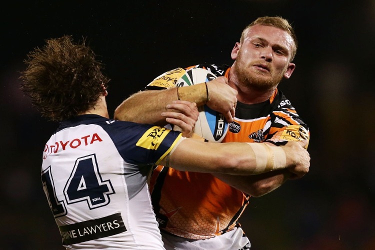 MATTHEW LODGE of the Tigers is tackled during the NRL match between the Wests Tigers and the North Queensland Cowboys at Campbelltown Sports Stadium in Sydney, Australia.