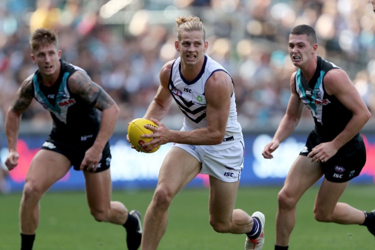 NAT FYFE of the Dockers is chased by Hamish Hartlett and Darcy Byrne-Jones of the Power during the 2018 AFL match between the Port Adelaide Power and the Fremantle Dockers at Adelaide Oval in Adelaide, Australia.