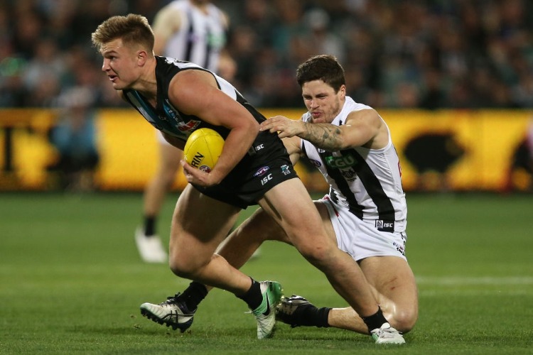 OLLIE WINES of the Power is tackled by JACK CRISP of the Magpies during the 2017 AFL match between the Port Adelaide Power and the Collingwood Magpies at the Adelaide Oval in Adelaide, Australia.