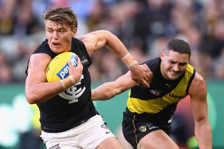 PATRICK CRIPPS of the Blues is tackled by Shaun Grigg of the Tigers during the AFL match between the Richmond Tigers and the Carlton Blues at MCG in Melbourne, Australia.