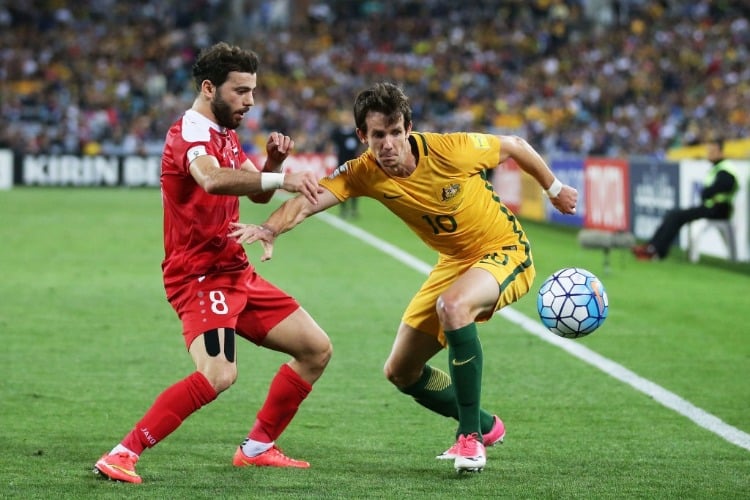 ROBBIE KRUSE of Australia is challenged by Mahmoud Al Mawas of Syria during the 2018 FIFA World Cup Asian Playoff match between the Australian Socceroos and Syria at ANZ Stadium in Sydney, Australia.
