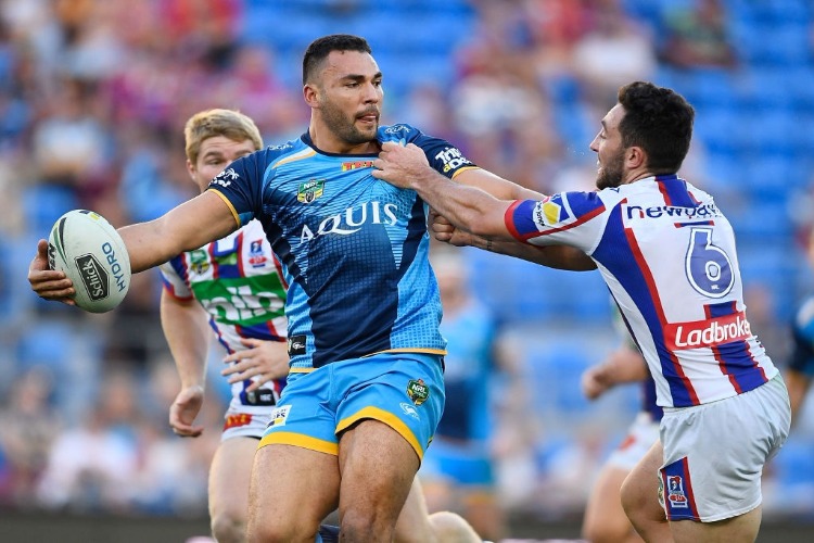 RYAN JAMES of the Titans looks to make a pass despite the tackle of Brock Lamb of the Knights during the NRL match between the Gold Coast Titans and the Newcastle Knights at Cbus Super Stadium in Gold Coast, Australia.
