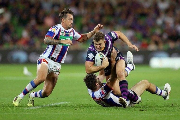 RYLEY JACKS of the Storm runs with the ball as he is tackled by the Knights defence during the round six NRL match between the Melbourne Storm and the Newcastle Knights at AAMI Park in Melbourne, Australia.