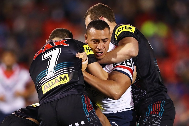 SIO SIUA TAUKEIAHO of the Roosters is tackled by the Panthers defence during the NRL match between the Penrith Panthers and the Sydney Roosters at Pepper Stadium in Sydney, Australia.