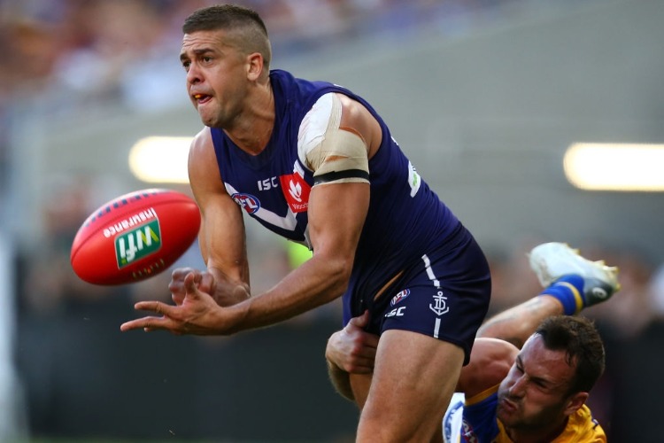 STEPHEN HILL of the Dockers handballs during the AFL match between the Fremantle Dockers and West Coast Eagles at Optus Stadium in Perth, Australia.