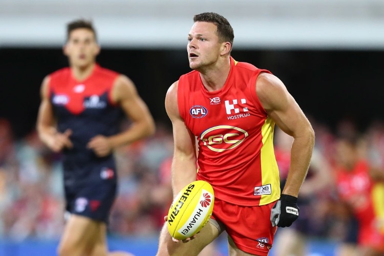 STEVEN MAY of the Suns handballs during the AFL match between the Gold Coast Suns and the Melbourne Demons at The Gabba in Brisbane, Australia.