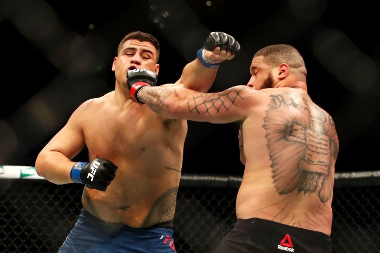 TAI TUIVASA of Australia punches Rashad Coulter of the USA in their heavyweight bout during the UFC Fight Night at Qudos Bank Arena in Sydney, Australia.